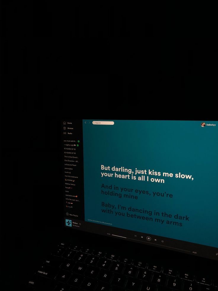 a laptop computer sitting on top of a black desk with a message written on the screen