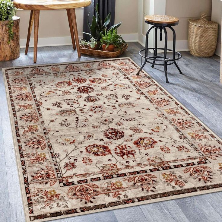 a large rug with an ornate design on the floor in a living room next to a table and chairs