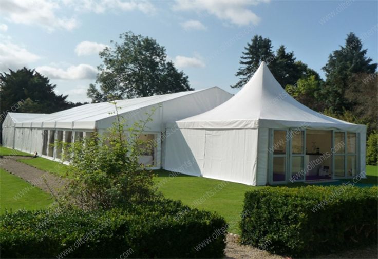 a large white tent set up on top of a lush green field