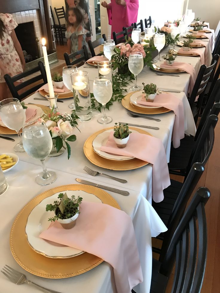 the table is set with pink and gold place settings