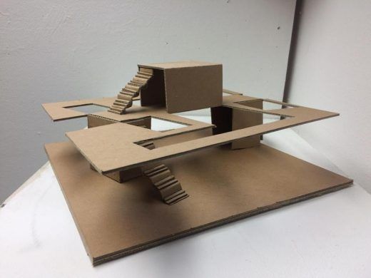 a model of a house made out of cardboard on top of a white countertop