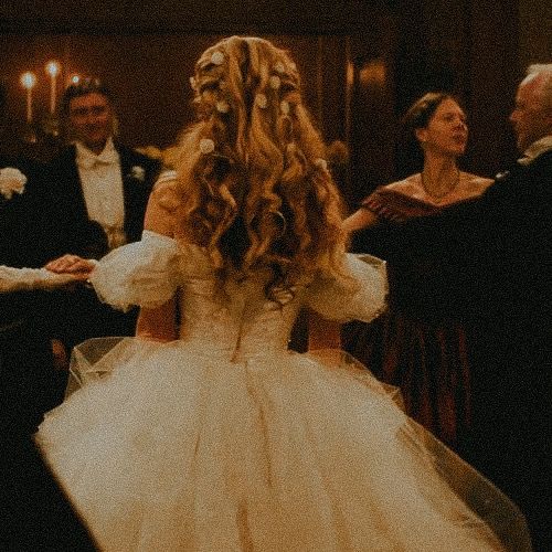 a woman in a wedding dress is walking down the aisle with other people around her