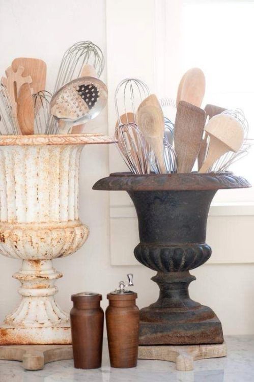 there are many kitchen utensils in the vase on the counter next to each other