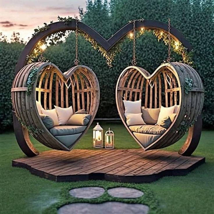 two heart shaped swings in the middle of a yard with lights hanging from it's sides