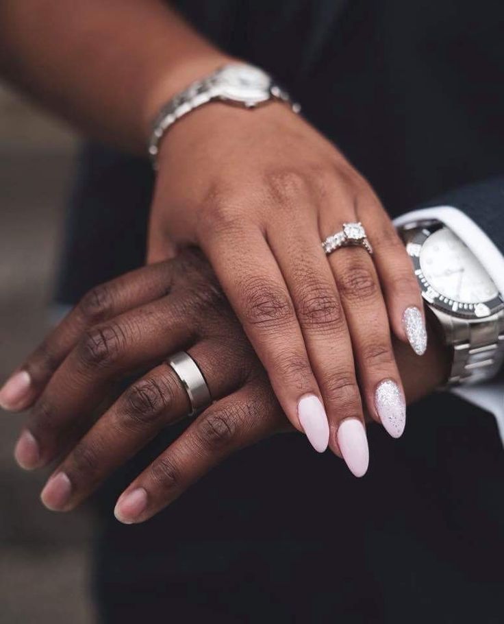 two hands holding each other while wearing wedding rings