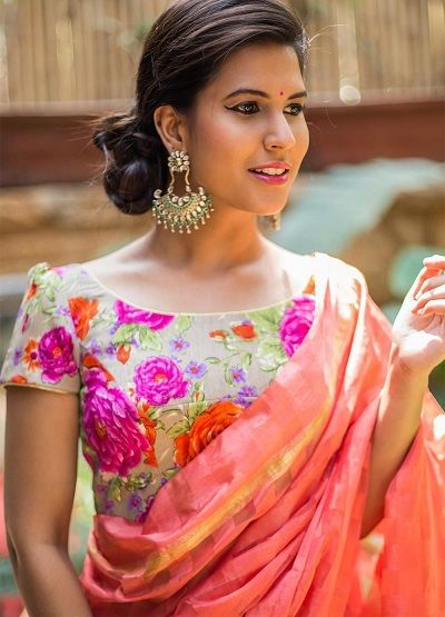 a woman wearing an orange and pink sari