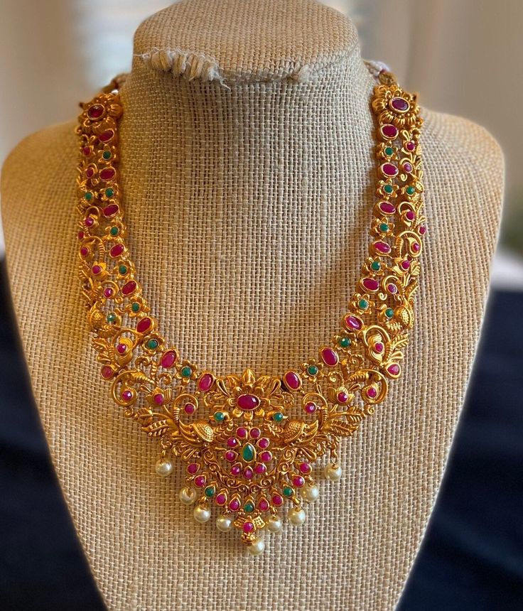 A gorgeous jewelry set consisting of two necklaces, one hip accessory, and one set of earrings. Both necklaces have adjustable strings. The small intricate work of flower designs, emeralds and rubies make this piece beautiful. Two Necklaces, Golden Jewelry, Ruby Necklace, American Diamond, Gorgeous Jewelry, One Set, Flower Designs, Necklace Set, Jewelry Set