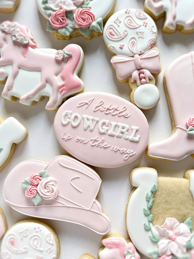 pink and white decorated cookies with the words cowgirl on them