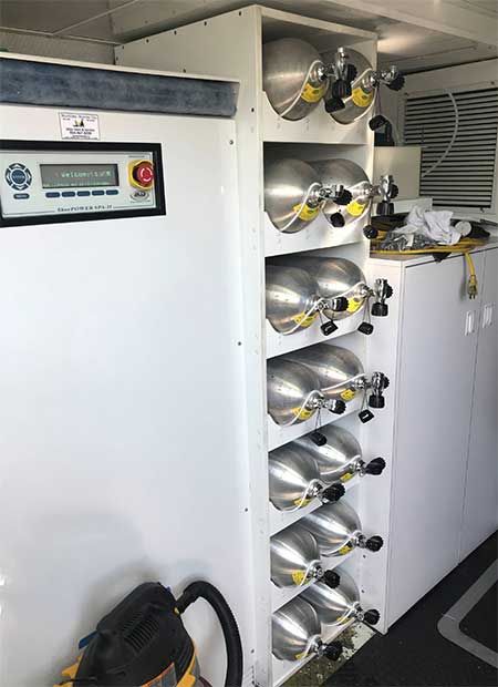 a room filled with lots of metal pots and pans next to a white wall