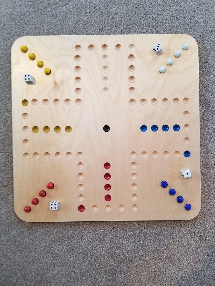 a wooden board game with several dices and numbers on the board, sitting on carpet