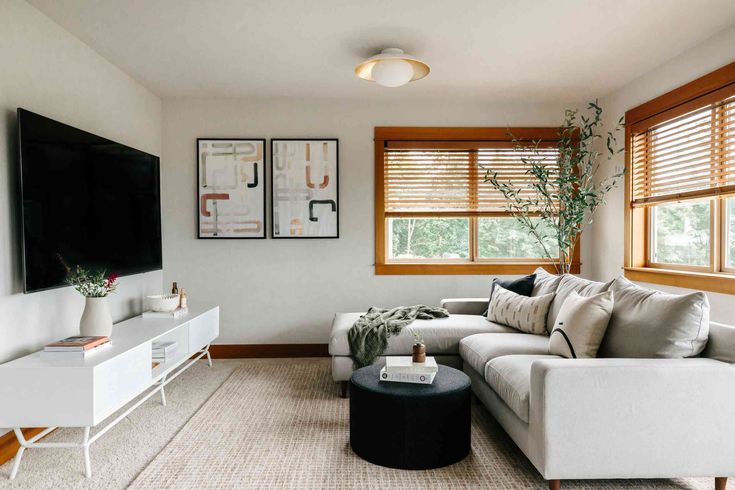 a living room filled with furniture and a large flat screen tv mounted on the wall