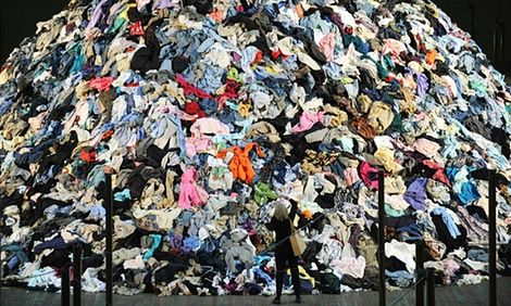 a large pile of clothes sitting on top of a metal fence