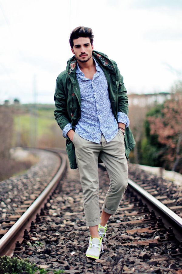 a man standing on train tracks with his hands in his pockets