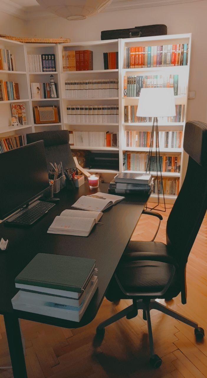 an office desk with bookshelves in the background