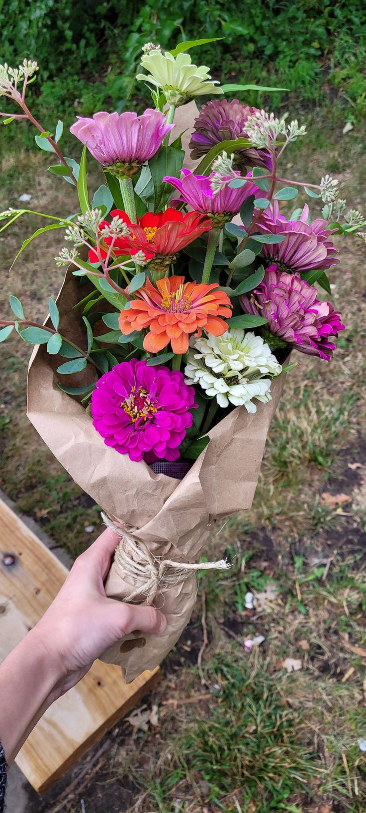 a person holding a bouquet of flowers in their hand