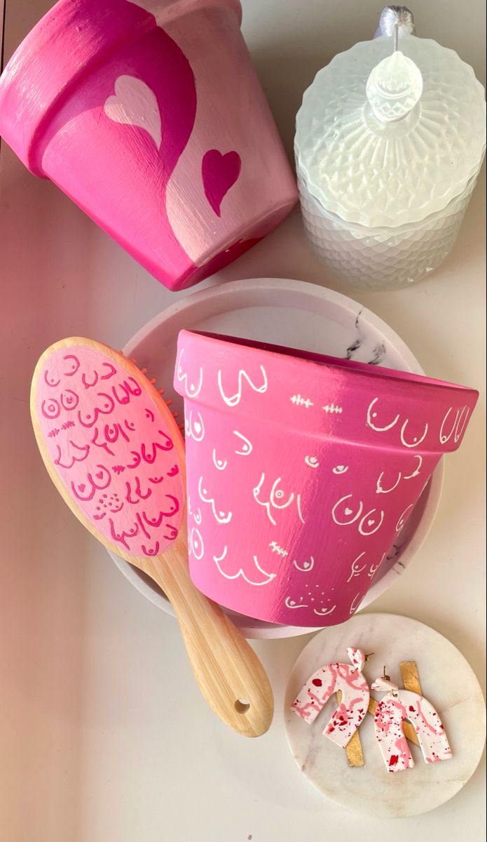 pink and white cupcakes on plates next to paper containers with hearts painted on them