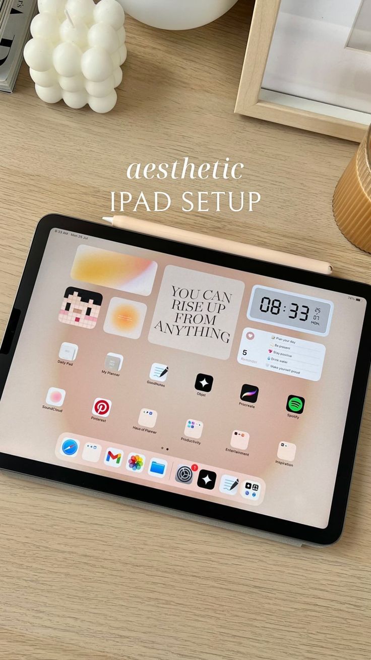 an ipad sitting on top of a wooden desk next to a clock and other items