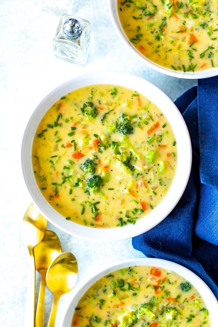 two bowls of soup with broccoli and carrots