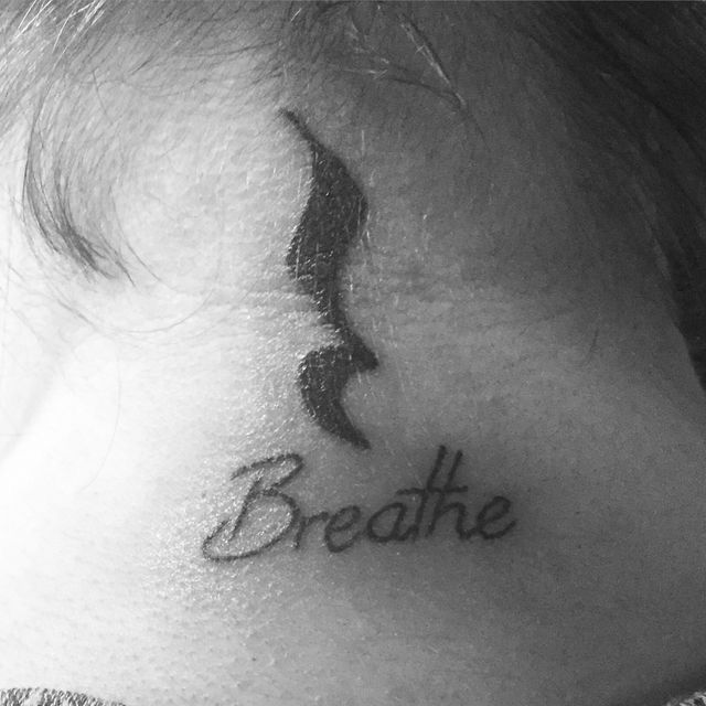 a black and white photo of a woman's neck with the word breathe on it