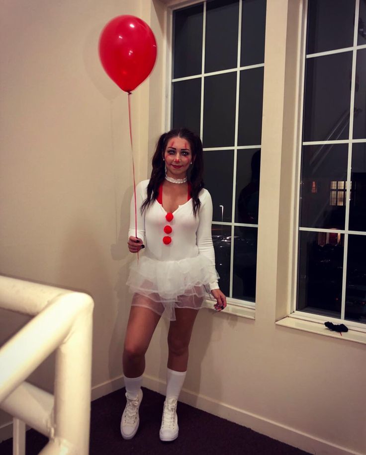 a woman dressed in white holding a red balloon