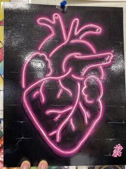 a neon drawing of a human heart on a brick wall with other art work in the background