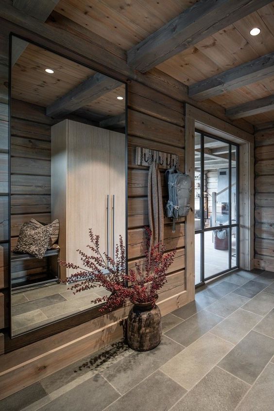 a room with wood paneling and tile flooring has a mirror on the wall