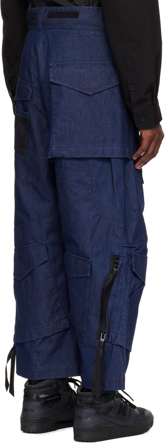 Non-stretch chambray jeans. Flap pockets throughout. · Paneled construction · Belt loops · Velcro detailing at waistband · Zip-fly · Mesh pocket at front and back leg · Tucks at knees · Two-way zip detailing at outseams · Bonded nylon taffeta lining Part of the Junya Watanabe MAN collection. Supplier color: Indigo Urban Denim Blue Cargo Pants With Belt Loops, Denim Cargo Pants With Dark Wash, Denim Cargo Pants With Belt Loops In Dark Wash, Blue Rigid Denim Cargo Pants, Blue Cargo Pocket Rigid Denim Pants, Blue Rigid Denim Pants With Cargo Pockets, Urban Dark Wash Cargo Pants With Patch Pockets, Urban Cargo Pants With Patch Pockets, Utility Cargo Jeans In Recycled Denim With Belt Loops