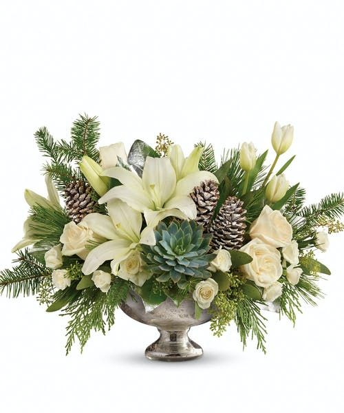 a silver vase filled with white flowers and pine cones