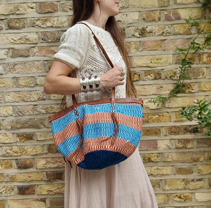 Amazing large sisal bucket bag in blue and red, true vintage from the 1970s or 1960s. This is a big woven basket bag, handmade in Africa. It has been hand woven from natural sisal fibres and genuine leather in tan brown. The leather has been hand tooled with a tribal pattern. These bags have become very rare but despite this bag's age, it's in excellent vintage condition. Would make an beautiful summer bag for any bohemian love or hippie chick. Width: 47cm = 18.5" Length: 38cm = 15" Strap: 38cm Vintage Bucket, Natural Baskets, Hippie Chick, Hippie Bags, Natural Sisal, Summer Bag, Woven Basket, Leather Conditioner, Basket Bag