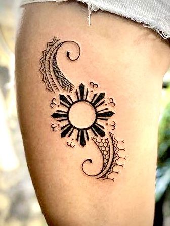 a woman's thigh with a tattoo design on her leg and the sun in the middle