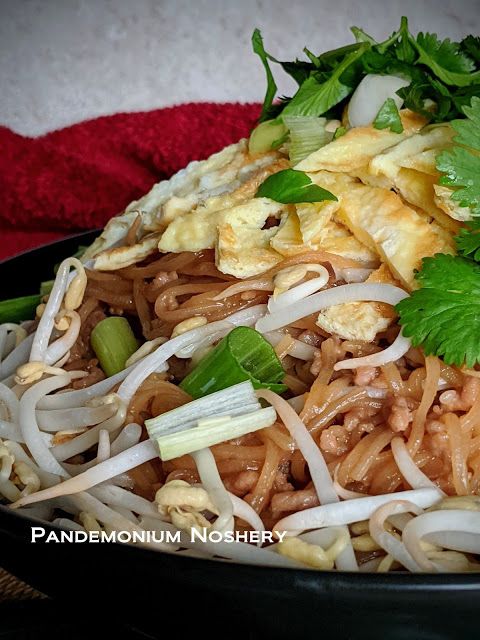 a bowl filled with noodles and vegetables on top of a table