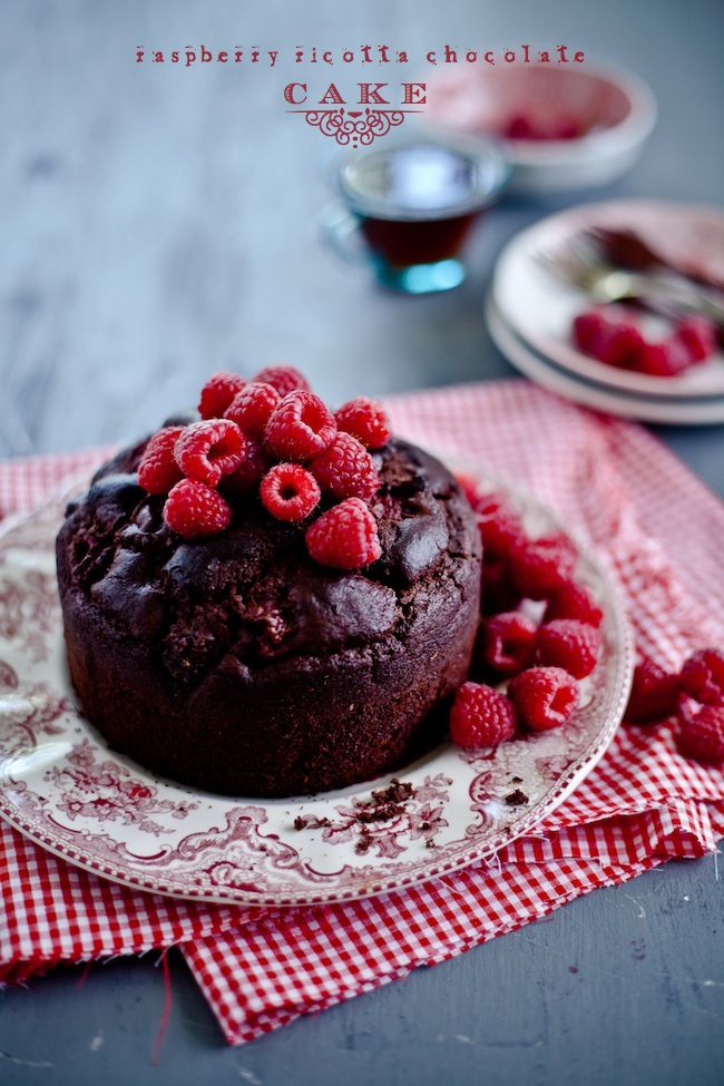 a chocolate cake with raspberries is on a plate