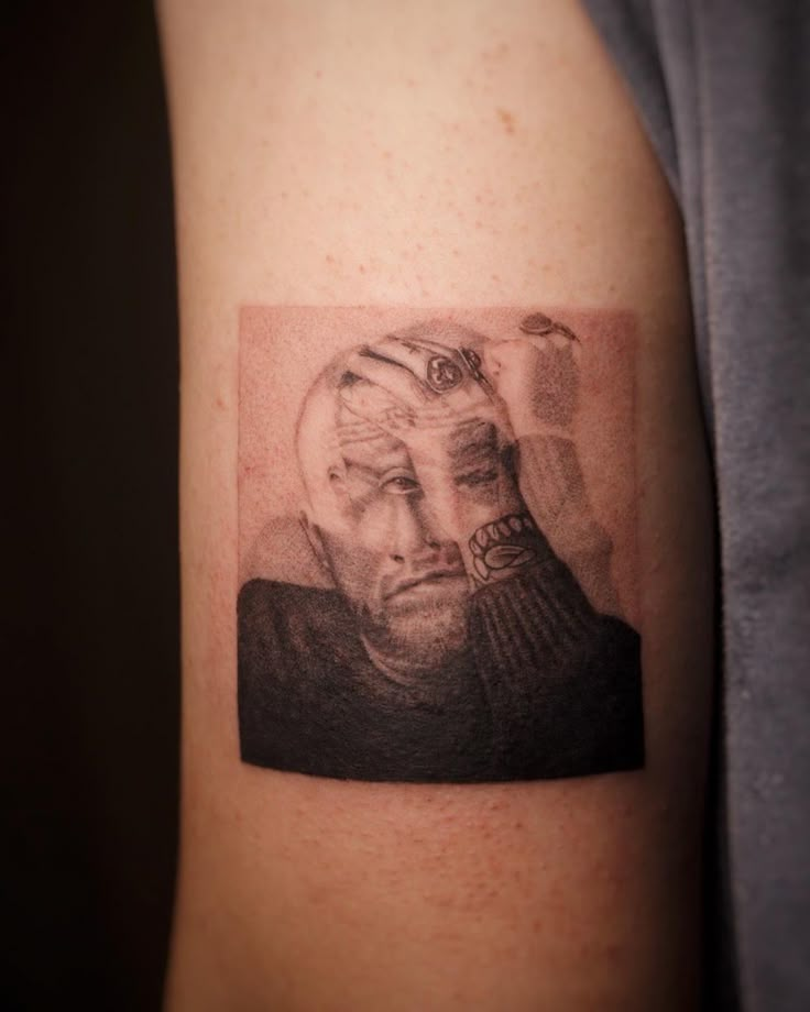 a man's arm with a black and white photo on it that has a portrait of himself