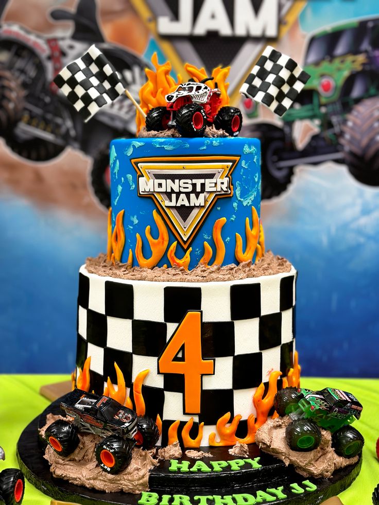 a birthday cake with monster jam on top and flames around the edges is decorated in black, white, and blue