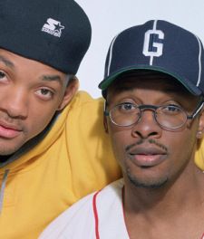 two young men wearing hats and glasses posing for a photo in front of a white background