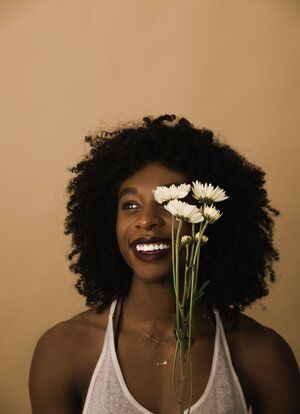 a woman holding flowers in front of her face