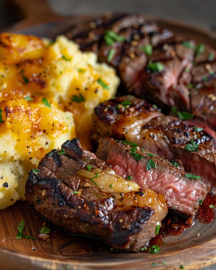 steak, potatoes and carrots on a wooden plate