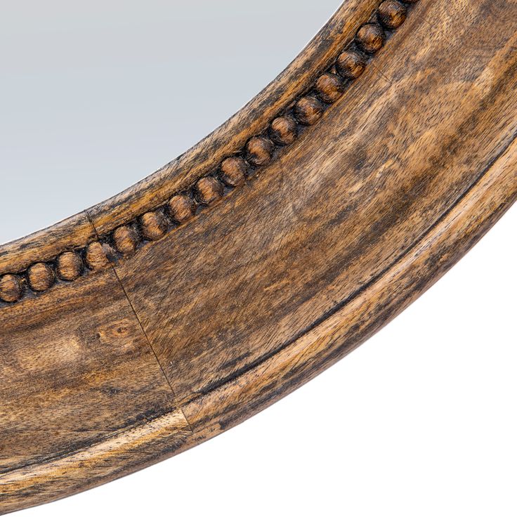 an oval wooden mirror with beading around the edges