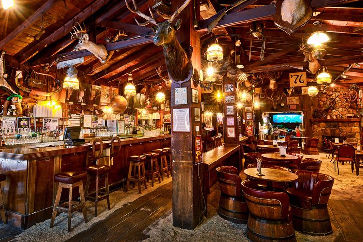 a bar with deer heads hanging from the ceiling