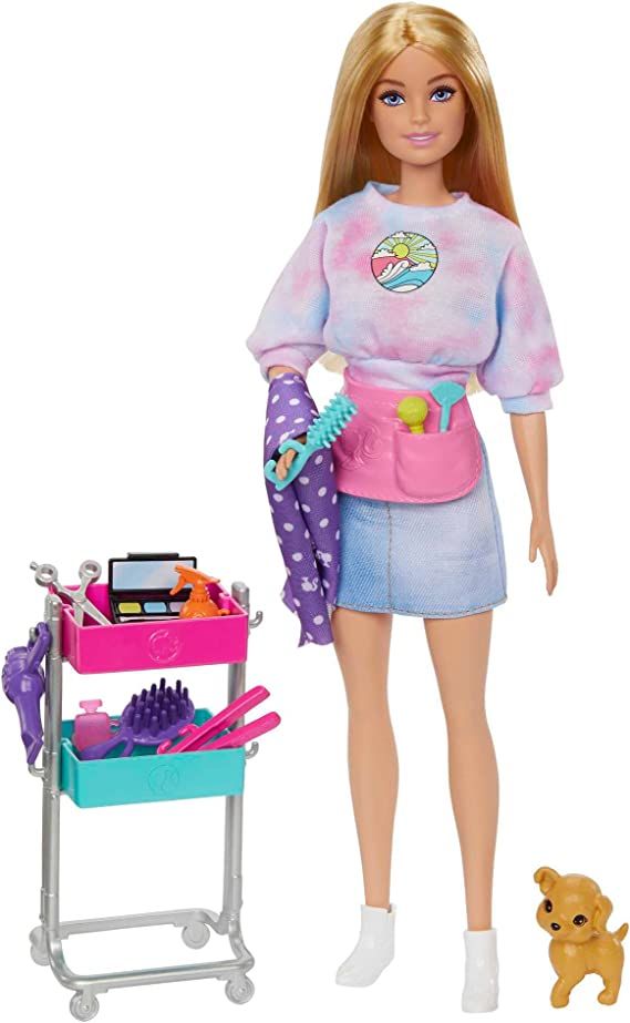 a barbie doll is standing next to a cart with cleaning supplies