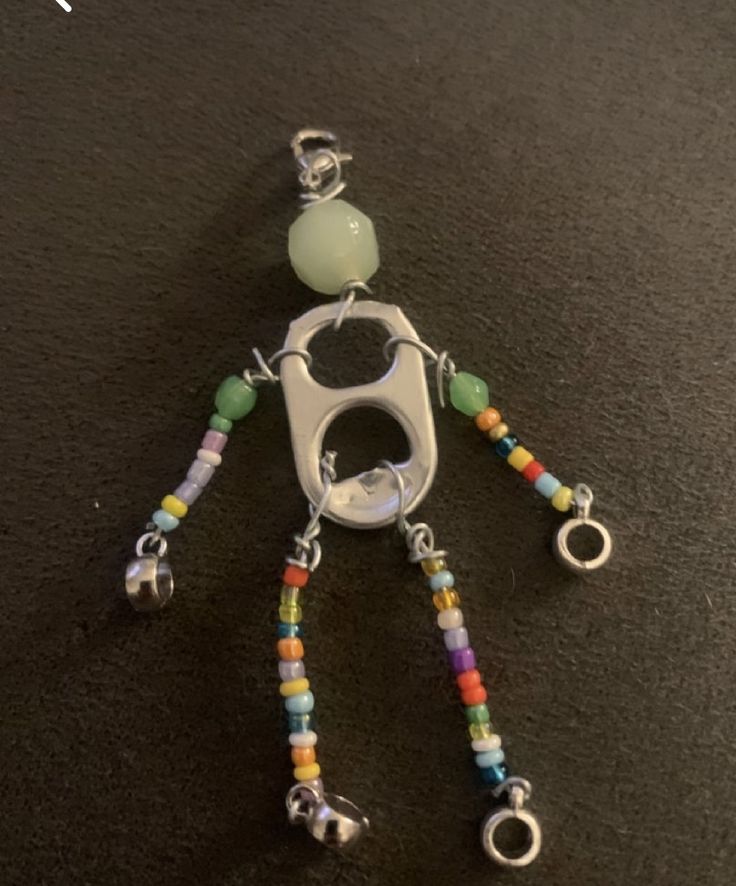 a keychain made out of beads and metal with a small figure on it