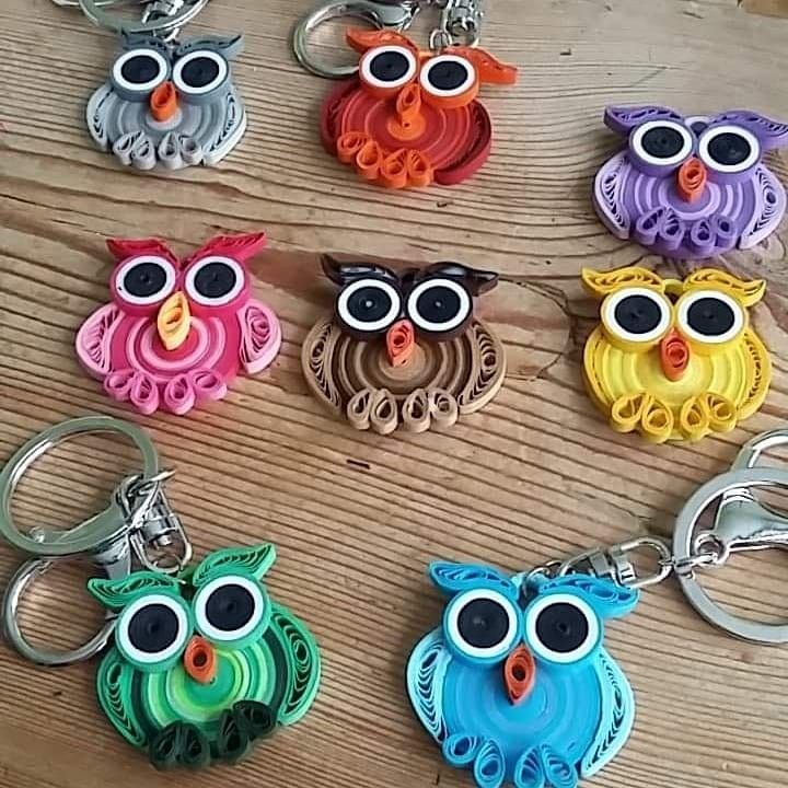 six owl shaped key chains sitting on top of a wooden table