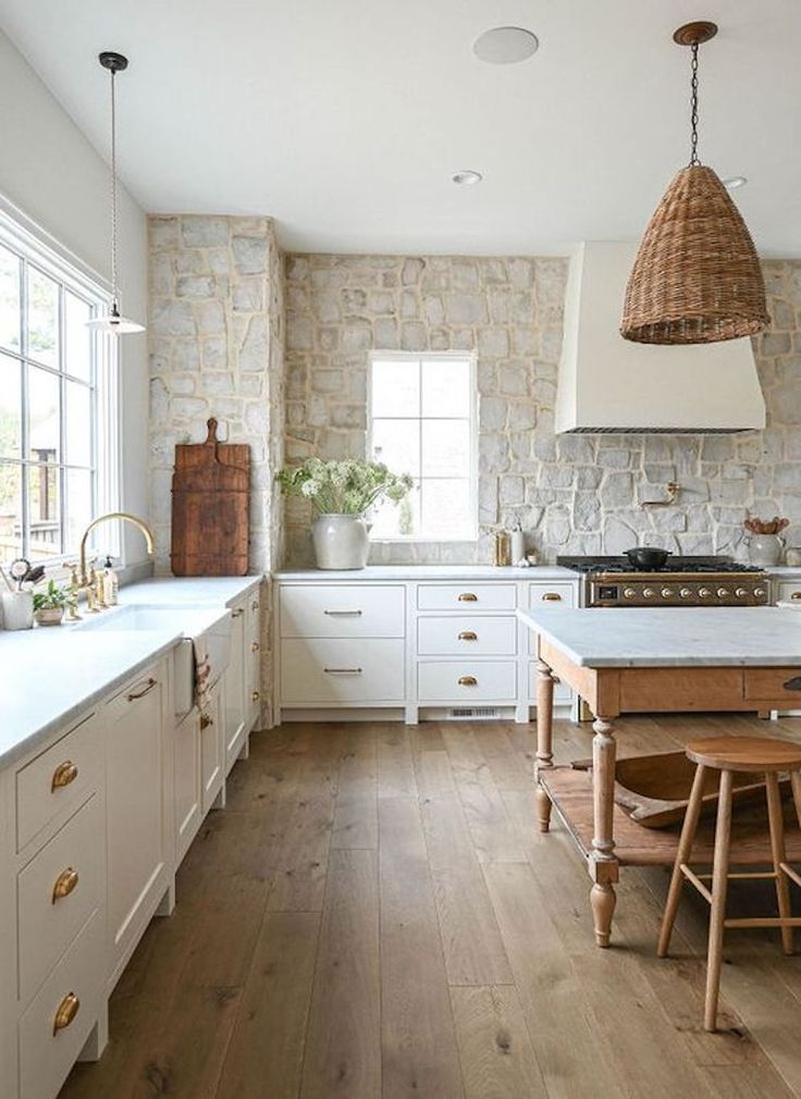 a kitchen with white cabinets and wood floors