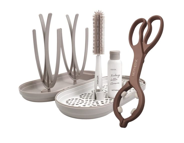 a pair of scissors, comb and other items in a holder on a white background