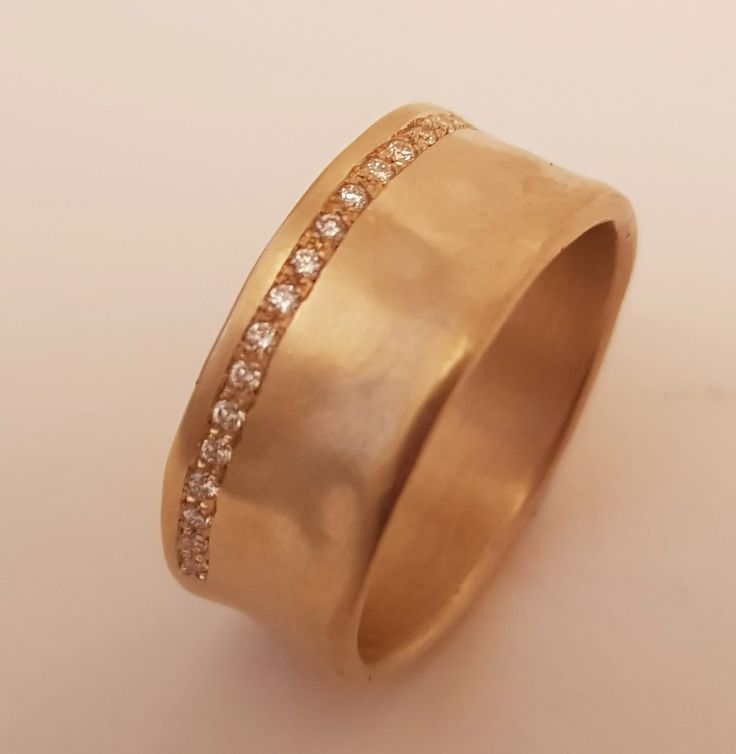 a gold wedding ring with diamonds on it