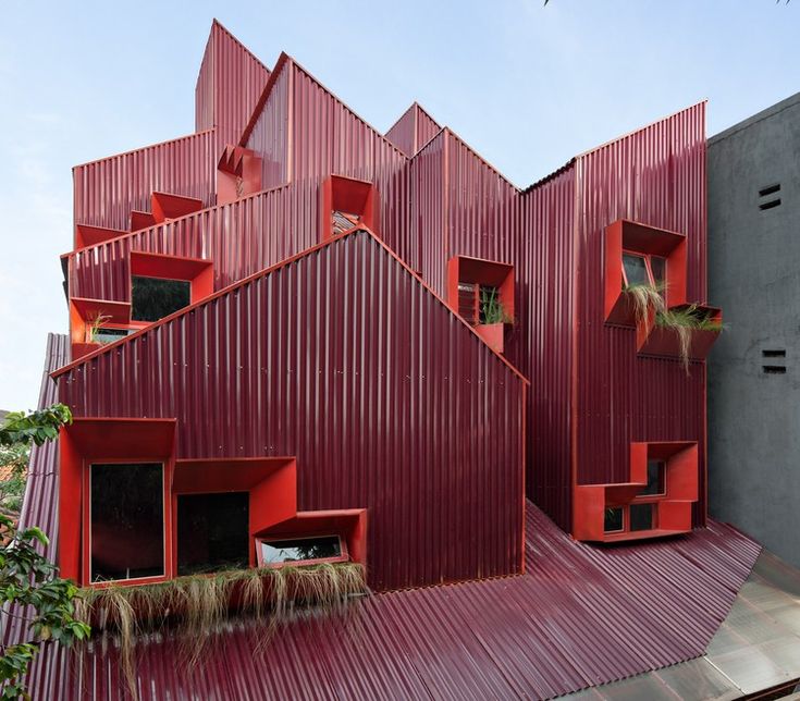 the red building has many windows on it's sides and is made out of corrugated