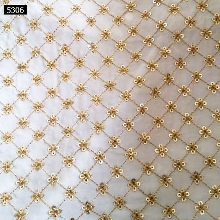 gold sequins on white fabric with small flowers and leaves in the center, as well as two smaller ones