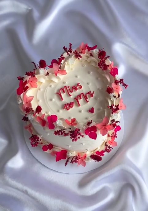 a white cake with red and pink flowers on it that says, happy new year