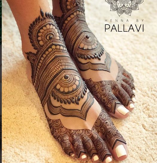 the feet are decorated with henna and intricate designs on it's legs,