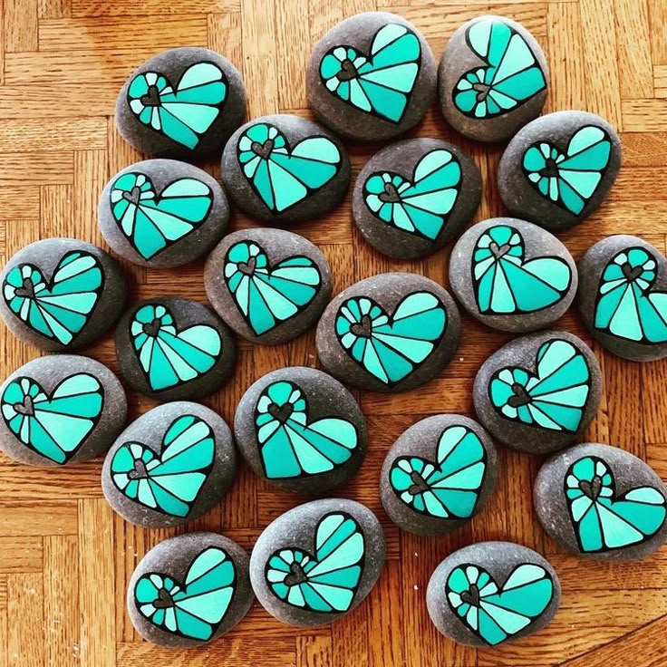 several heart shaped cookies sitting on top of a wooden table with blue frosting in the shape of hearts